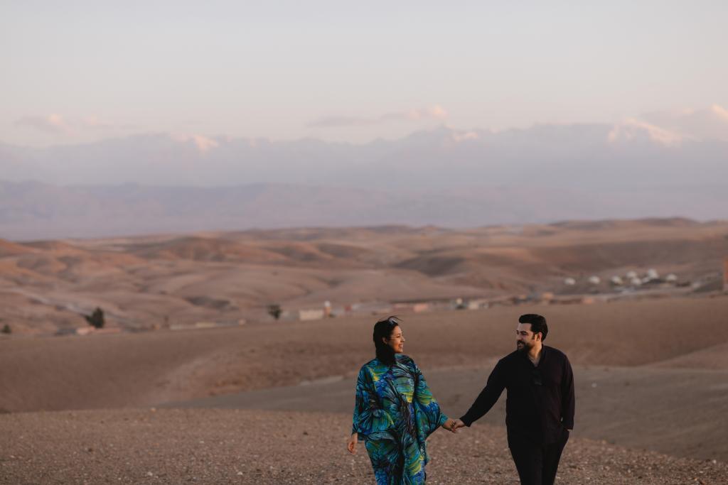 Trouwfotografen Iman en Chaima van Maison Amanti wandelen samen in de Agafay-woestijn bij zonsondergang