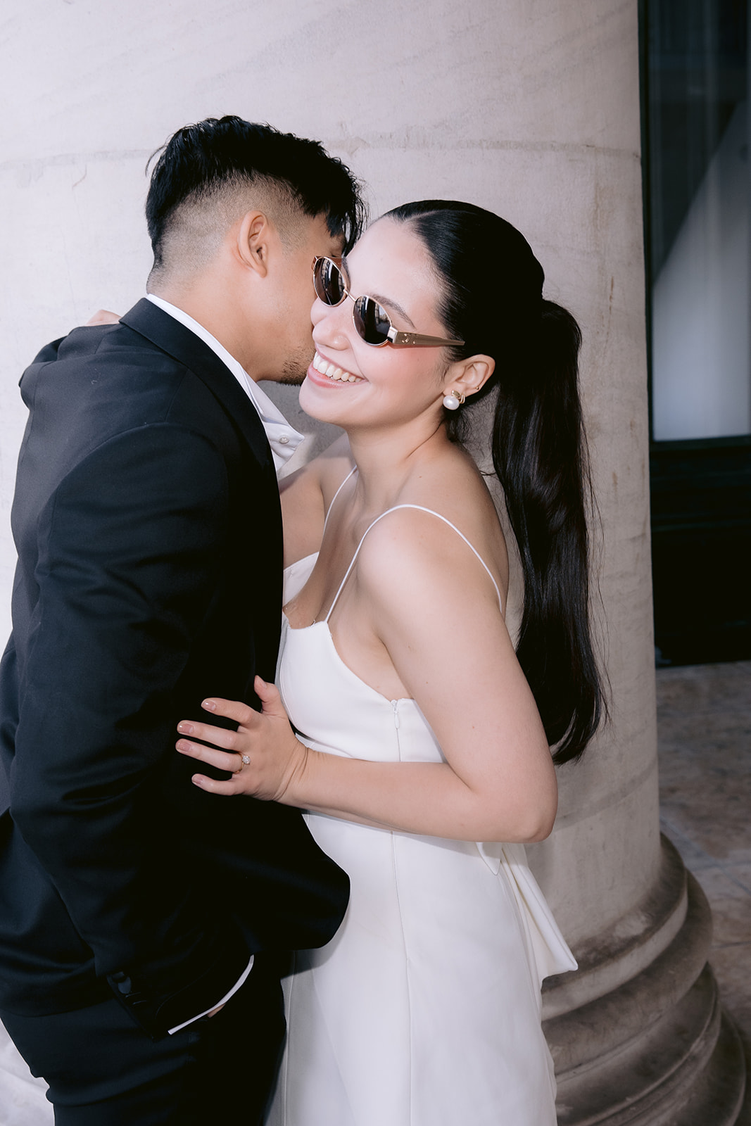 Couple sharing a playful moment outside a building in Brussels during their loveshoot