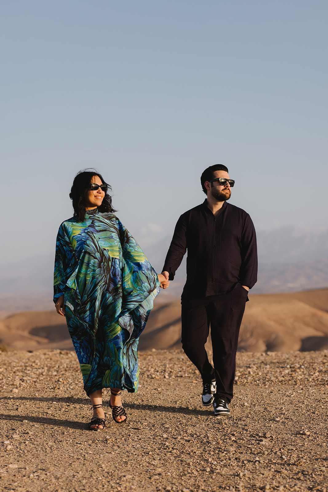 Couple walking hand in hand in the Agafay desert in Morocco